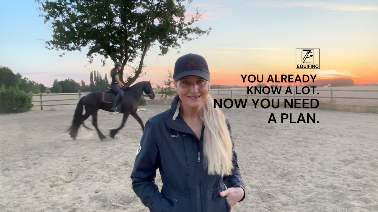 Sandra Peters in the arena while a student rides a young horse behind her